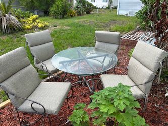 Iron table with glass top and four chairs