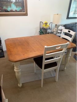 Farm table with four chairs .