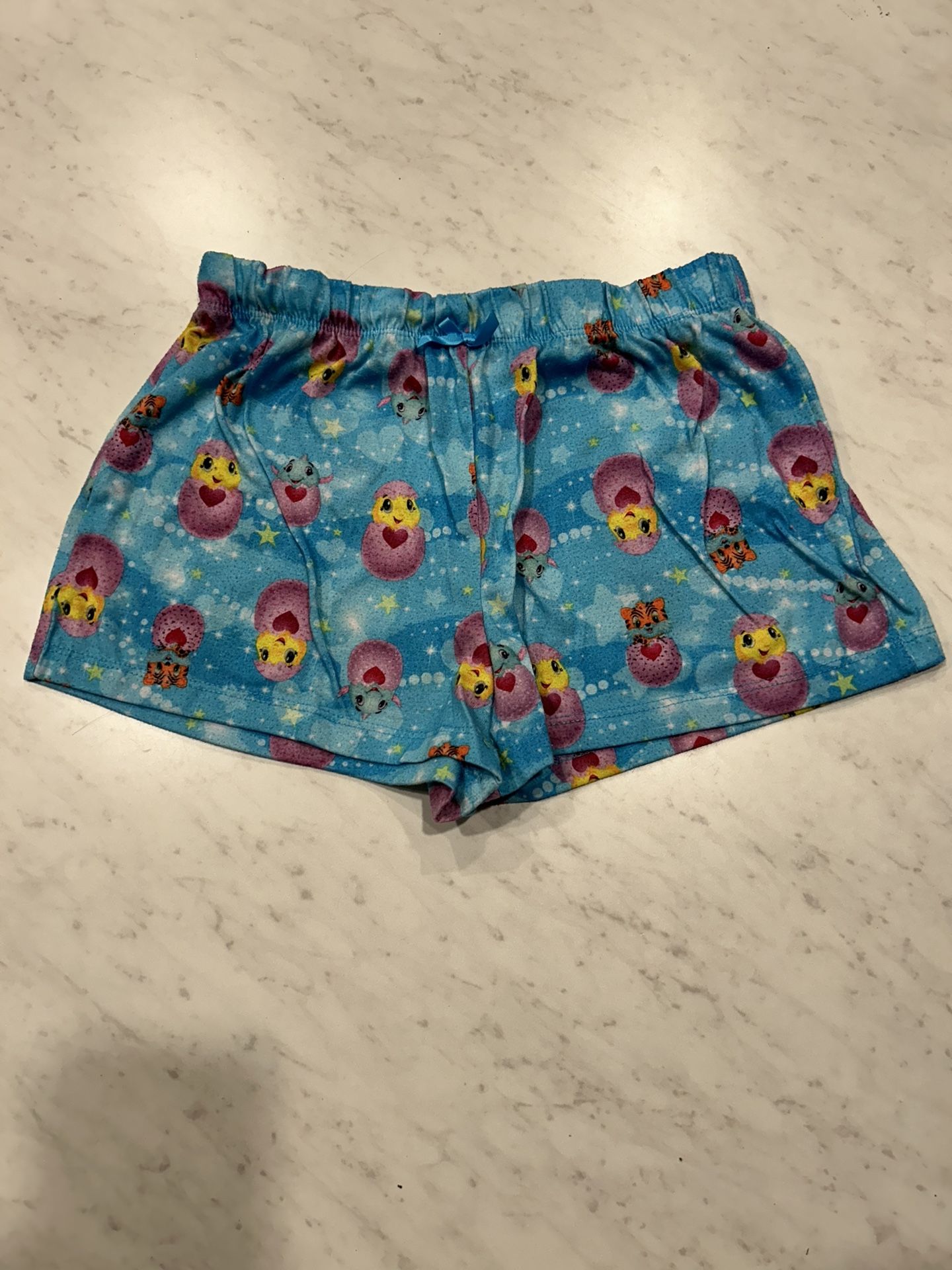 Hatchimals Blue shorts with colorful cartoon print. Elastic waistband.