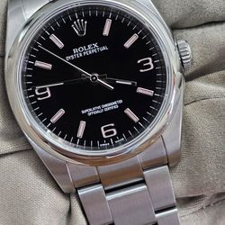 Rolex Oyster Perpetual black and pink dial.