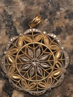Circa 1985, a 31mm round 10k yellow Rolled gold filigree fashion medallion pendant.