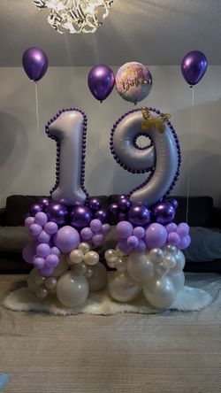stacked number balloon arrangement with purple & gold accents. 