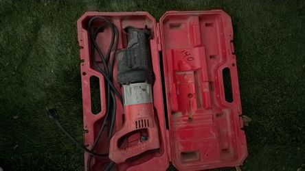 Tool is a Milwaukee electric saber saw, commonly known as Sawzall.