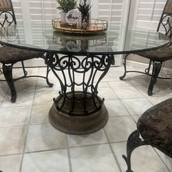 BEAUTIFUL DINETTE GLASS TABLE (48 INCH RIUND  WITH STONE BASE - 4 WROUGHT IRON CHAIRS WITH UPHOLSTERED SEATS - PRICE IS FIRM