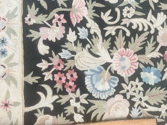 Handmade multi-colored floral rug with a fabric back. 48" x 72". One small flaw