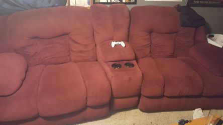Huge red reclineable couch with middle piece cupholder