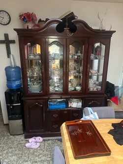 • Style: Traditional / French Country style with a rich dark mahogany or cherry finish. • Upper Section: Multi-pane glass doors with interior display 