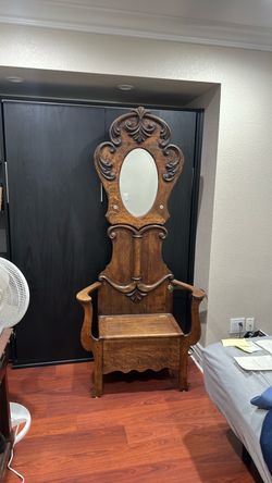 antique Press-Carved Golden/Tiger Oak Hall Seat (or Hall Tree) with an oval mirror and a lift-top storage bench seat.