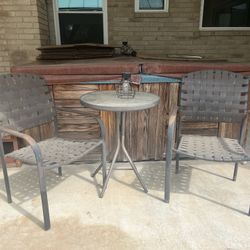 round top outdoor table with two chairs