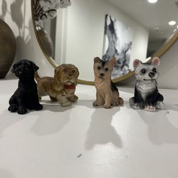 Four statuettes of dogs of different breeds