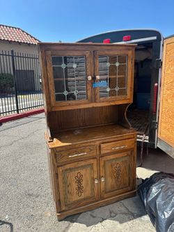 mid-century oak two-piece hutch features stained glass door inserts with subtle green accents
