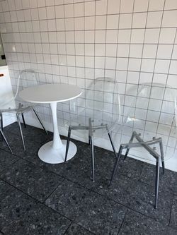 Round White Tulip Table with Clear Modern Chairs