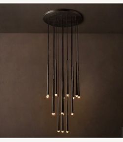 AQUITAINE ROUND CHANDELIER. It includes solid brass forms suspended from slender black cords. Inset LEDs at the faceted glass tips offer warm, glowing