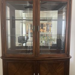  solid wood china cabinet with glass display top and storage base.