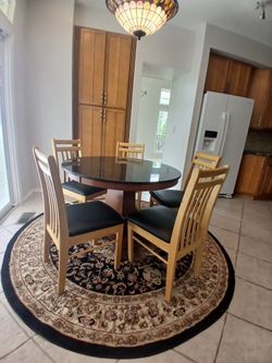 Round marble kitchen table, chairs, and rug.