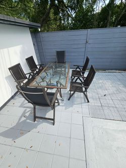 Mesa  de metal y vidrio para exterior con 6 sillas