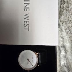This is a Nine West Felicity Analog Wrist Watch with a white dial, rose gold-tone case, and black faux leather strap. 