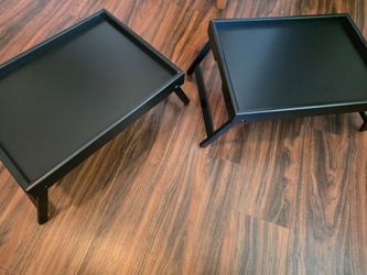 black, bamboo lap desk features foldable legs for easy storage and serves as a versatile surface for eating or working.