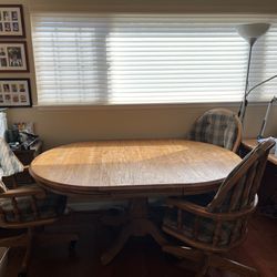 Solid oak extendable dining/study table & 3 cushioned rolling chairs