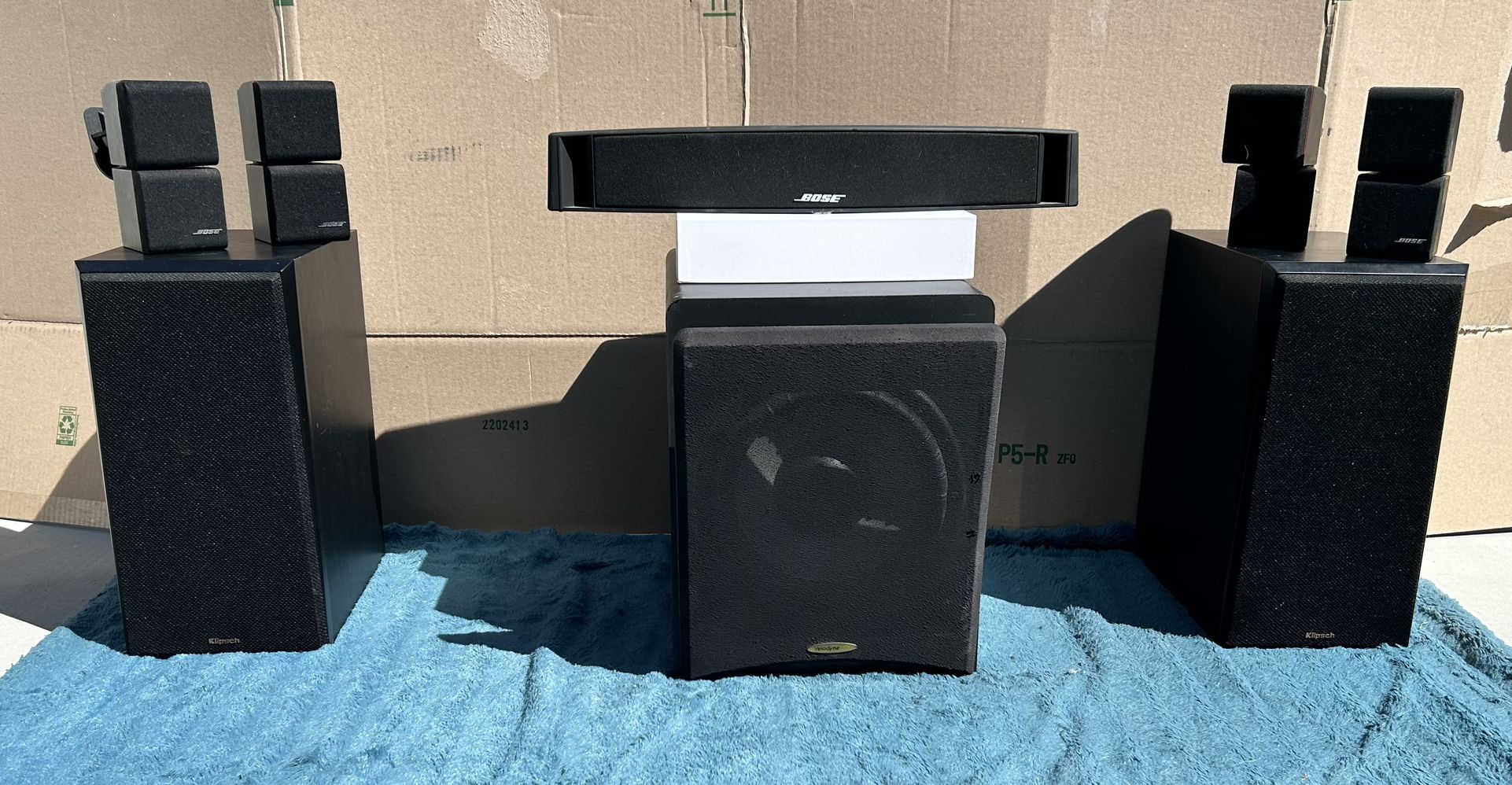 High-quality home audio setup featuring 4 Bose cube speakers, 2 Klipsch RP-600M bookshelf speakers, a Bose VCS-10 center channel, and a Velodyne VX-10