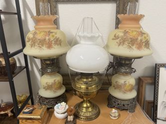 Antique oil lamps with floral glass shades and brass bases