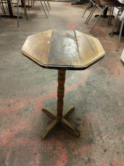 Small used wooden pedestal style table.