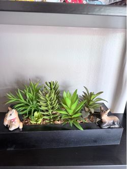 artificial succulent arrangements in a black wooden planter.