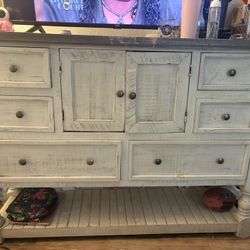 This is a rustic or farmhouse-style dresser or chest of drawers.  