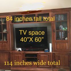 Walnut-finish entertainment system with lots of storage, display space, and room for huge flatscreen TV. 