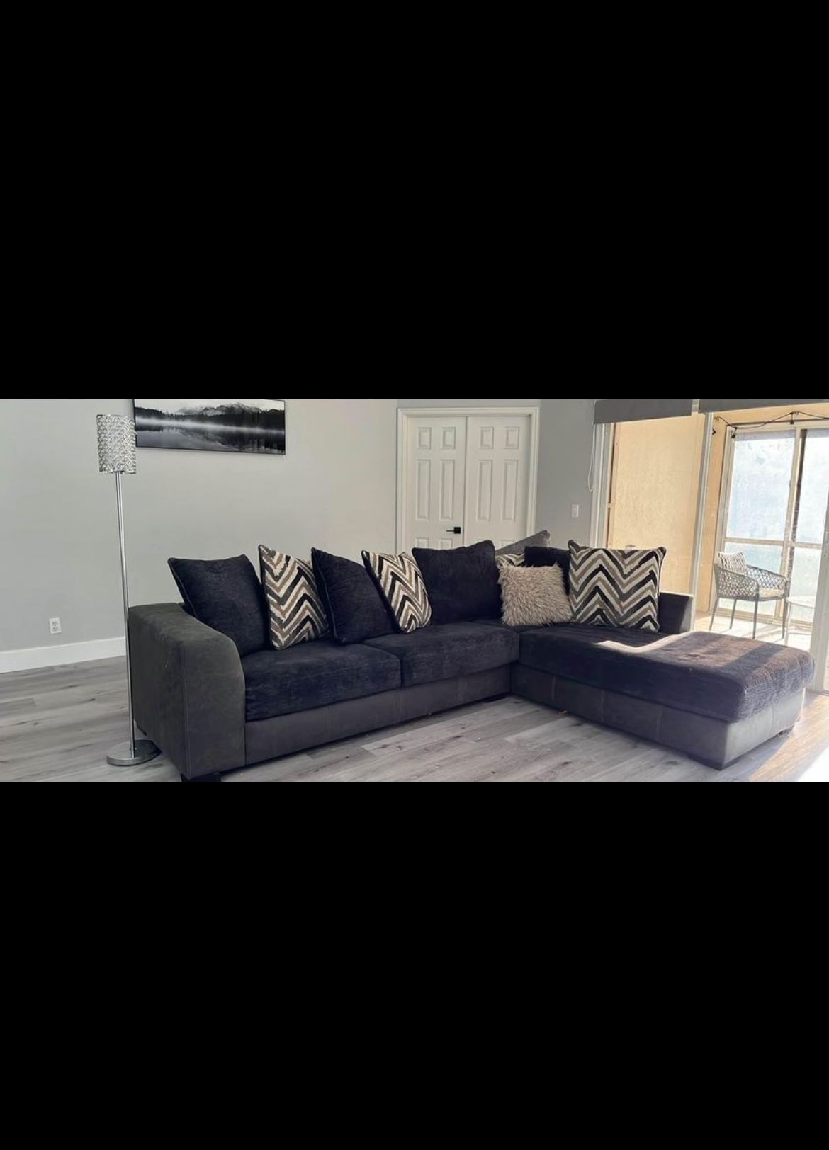 10 X 8 Black Sectional couch with a bunch of pillows
