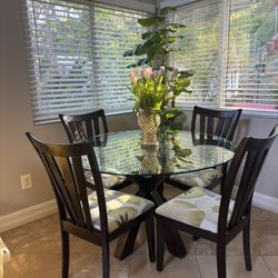 Glass top dining table with 4 chairs for sale.