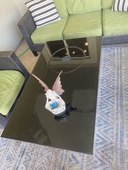 Outdoor wicker fire pit table with glass top.