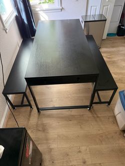 Black dining table set with two matching benches.