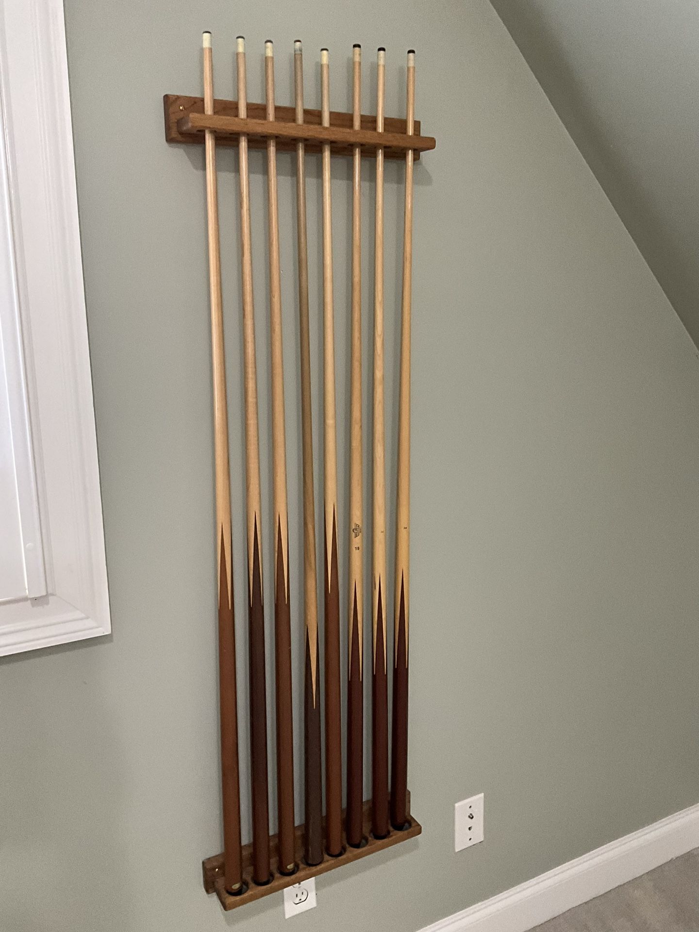 Variety Of Different Pool Sticks And Mount