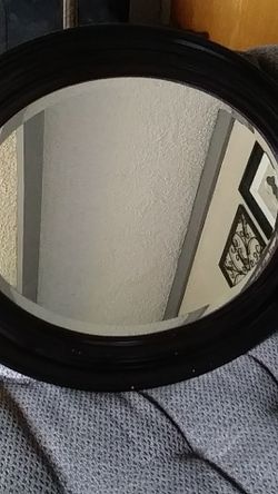 Beveled oval mirror. Looks like mohagany wood.