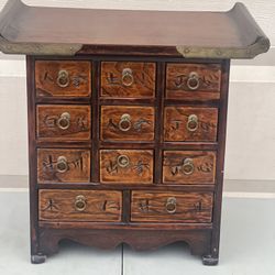 Asian Korea Wooden Brass Eleven Drawer Apothecary Chest/ Jewelry Trinket Box. Used in good condition with minor cosmetic blemishes. These blemishes ar