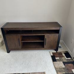 Brown wood TV stand with two closable side cabinets