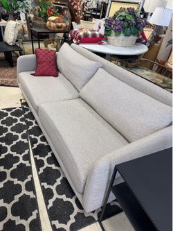 Sofa in a buff-colored pebble weave fabric.