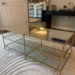 Sleek and modern coffee table with a gold metal frame and glass top, perfect for elevating any living room space. The clean lines and open design make