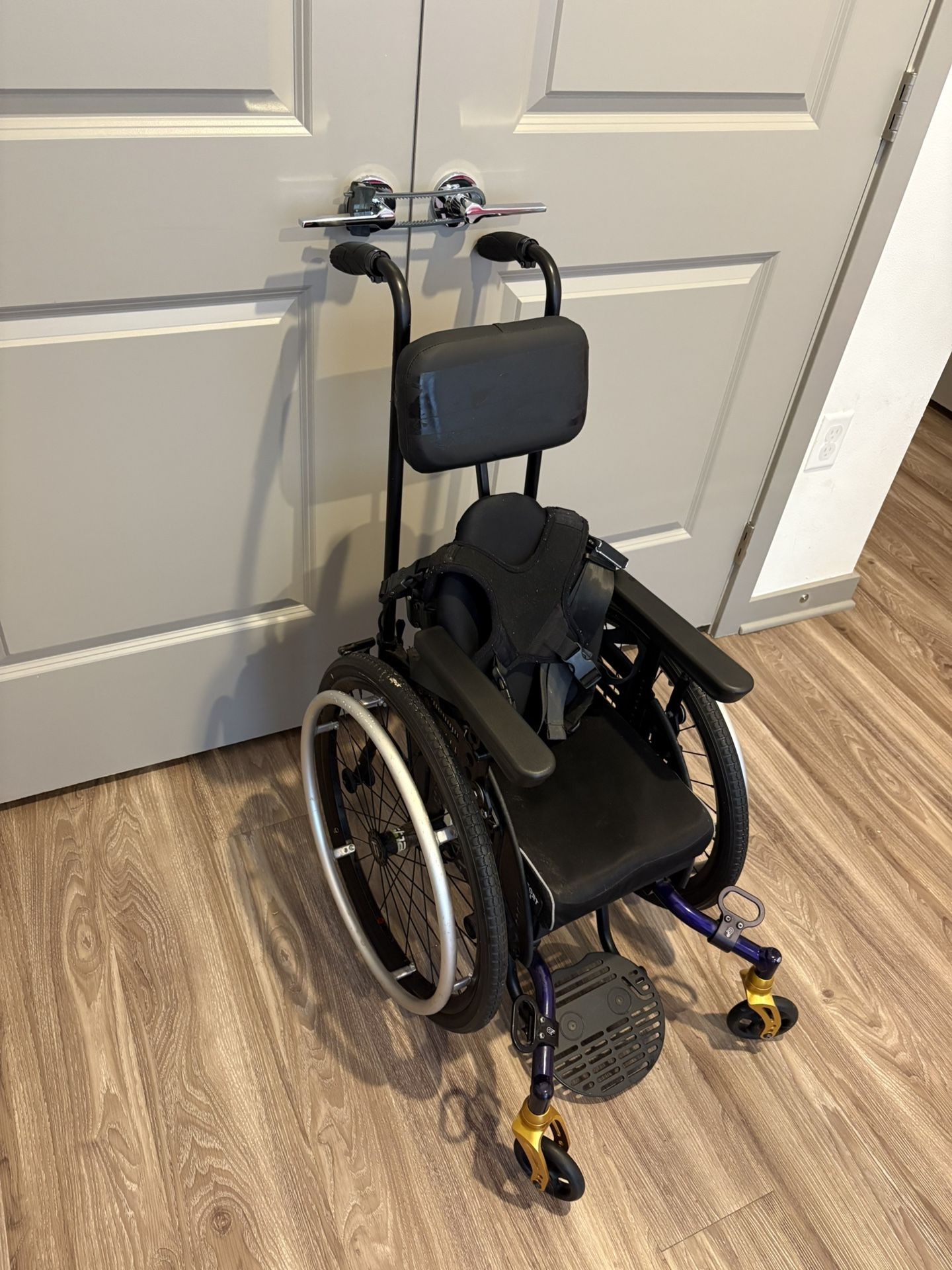 Kids Adaptive Wheelchair With A Four Point Harness And Seat Belt
