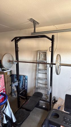 Squat rack with bench, plates, and Olympic bar