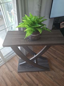 Entry Table. 31 1/2 Inches Long, 12 Inches Wide, 34 Inches Tall. Brownish Grey Color. Plant Not Included. In Great Condition. Pick Up Only.