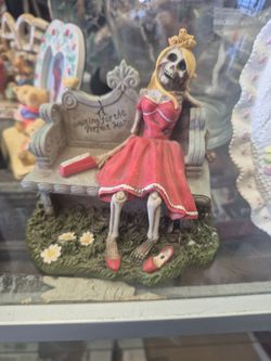 Summit Collection Gothic "Waiting for the Perfect Man" skeleton figurine featuring a blonde skeleton in a red dress sitting on a bench.