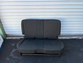black cloth OEM rear seat removed from a 2011-2016 Jeep Wrangler https://offerup.com/redirect/?o=NC1kb29yLkl0 is designed as a second-row bench seat.