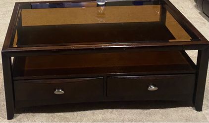 Solid wood coffee table with glass top.