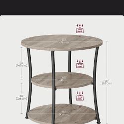 Stylish 3-tier round side table. Light wood grain shelves, black metal frame. Measures 21.7" tall, top shelf 21.3" diameter. Middle shelf 16.5" diamet