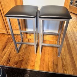 Two 23” tall stools, gray w faux black leather tops