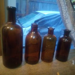 4 Large Antique Brown Bottles, Two Of The Bottles Have  Lettering 