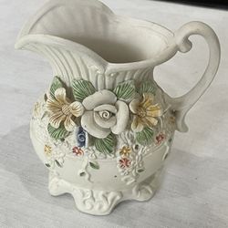 Ceramic pitcher with applied floral decorations in Capodimonte style.