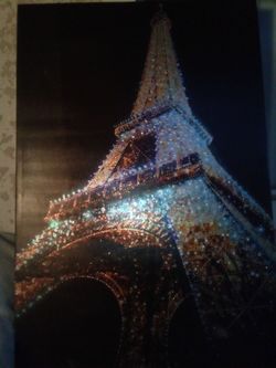 Eiffel Tower lit up at night against a black background